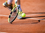 Ein Tennisspieler schlägt einen Ball mit seinem Schläger